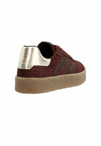 Burgundy sneaker made of textured material with silver heel accent, lacing, and a rubber sole with a patterned tread.