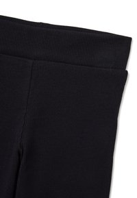 Zwarte leggings met een geribbelde textuur. Voorzien van een brede, elastische tailleband. De stof lijkt zacht en rekbaar, ontworpen voor comfort en flexibiliteit.