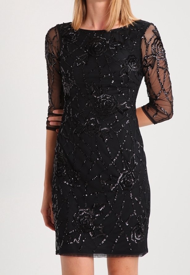 Svart kort klänning med genomskinliga trekvartärmar. Har intrikata paljettblommönster och pärldetaljer på en figurnära siluett.