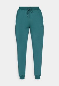 Teal joggebukser laget av mykt stoff, med elastisk midje og snøring, ribbede ankler og sidelommer.