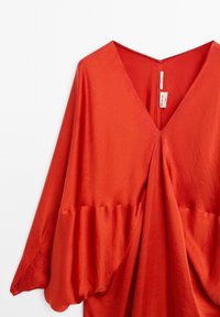 Rode blouse met een diepe V-hals, brede mouwen en een geplooide zoom. Zachte, lichte stof met een gladde textuur; heeft een sluiting aan de achterkant.