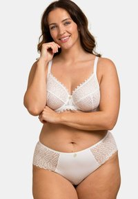 Ensemble en blanc comprenant un bralette en dentelle et un slip taille haute, avec des motifs géométriques, des bords festonnés et un petit bouton décoratif.