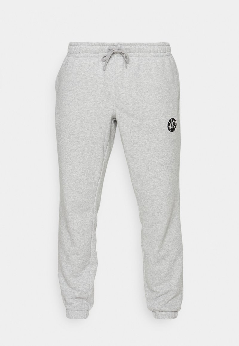 Hellgraue Sweatpants mit elastischem Bund und Bündchen, Kordelzug und einem kleinen schwarzen runden Logo auf dem rechten Oberschenkel.