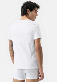 Korte mouwen witte t-shirt van katoen, met een ronde hals en een relaxte pasvorm, gezien vanaf de achterkant. Eenvoudig ontwerp, geen patronen.