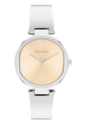 Reloj redondo de acero inoxidable plateado con un acabado suave y pulido, esfera dorada con efecto sol, marcadores blancos y correa de metal flexible.