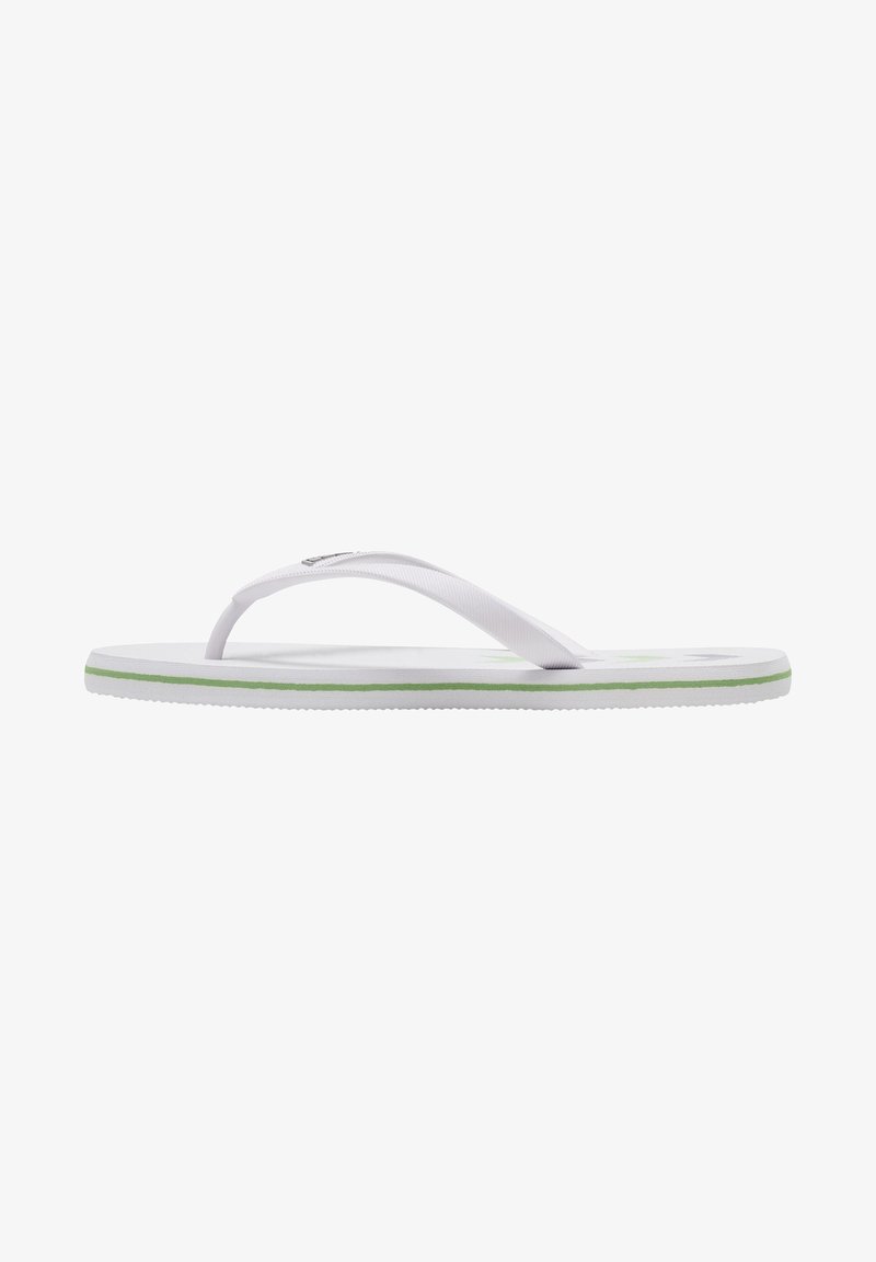 Vit flip-flop med en texturerad rem, grön kant och platt sula. Minimalistisk design med flexibelt gummi för komfort.