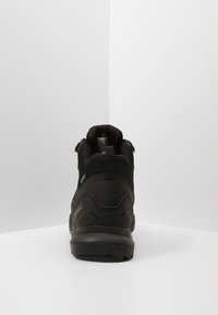 Czarne buty trekkingowe z wysoką cholewką, teksturowanym materiałem i amortyzowaną podeszwą, z logo po boku oraz wodoodporną konstrukcją.