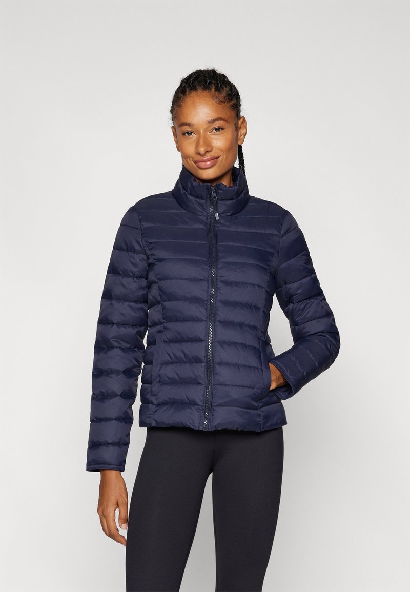 Manteau en duvet bleu marine avec un col haut, un design à couture verticale et une fermeture éclair. Dispose de poches avant et d'une texture lisse et isolante.