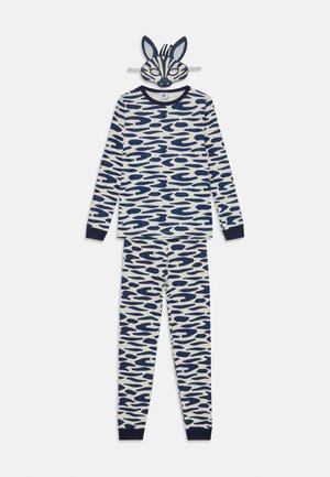 Barnens pyjamas set med långa ärmar och byxor i krämfärg med ett marinblått abstrakt vågmönster; inkluderar en mask som liknar djurdrag.