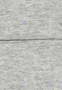 Baumwollstoff mit einem hellgrauen und blauen Fischgrätenmuster, der eine glatte Textur und einen dezenten Glanz aufweist. Nahtdetail sichtbar.