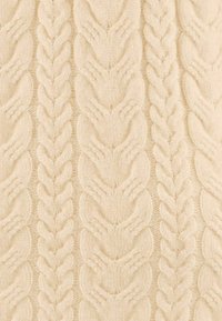 Un tessuto a maglia color crema caratterizzato da un motivo a treccia testurizzato, con trecce intrecciate e sezioni lisce, che creano un aspetto morbido e accogliente.