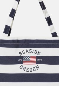 Sac cabas rayé bleu marine et blanc avec « Seaside Oregon », drapeau américain et coordonnées 45°N 123°W imprimés sur le devant.