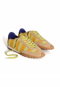 Zapatillas ligeras con un upper de textil tejido en amarillo y verde, detalles en gamuza beige, pestañas en el talón moradas y suela de goma.