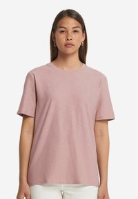 Rosa bomull t-shirt med korta ärmar, rund halsringning och en avslappnad passform. Slät textur och minimal design utan mönster eller detaljer.