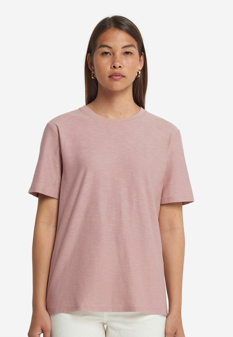 Rosa bomull t-shirt med korta ärmar, rund halsringning och en avslappnad passform. Slät textur och minimal design utan mönster eller detaljer.