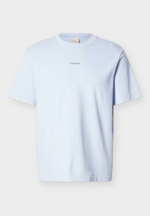 Šviesiai mėlynas medvilninis marškinėlis su apvalia iškirpte ir trumpomis rankovėmis, ant krūtinės esančiu mažu juodu „Calvin Klein“ logotipu.