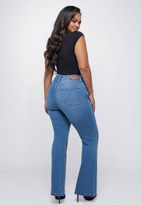 High-waisted flared jeans in medium blue denim met een gladde textuur, achterzakken en een leren logo patch op de tailleband.