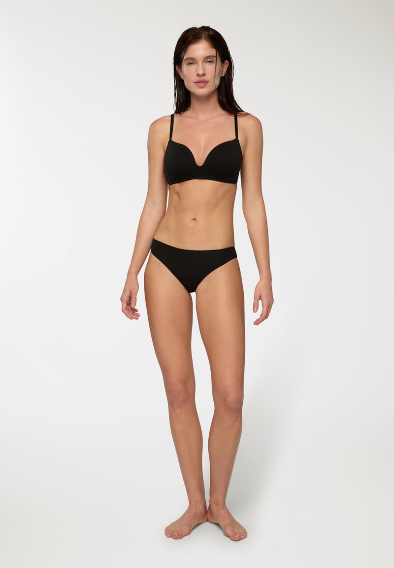Set di bikini nero con reggiseno imbottito e scollatura profonda, dotato di spalline regolabili, abbinato a slip a vita bassa coordinati. Tessuto morbido e liscio.