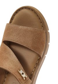 Brown suede slide sandal with two wide straps, smooth inner lining, and gold hardware accent. Textured sole for grip.