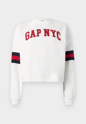 Biela skrátená mikina s nápisom "GAP NYC" v červenej farbe. Rukávy sú zdobené námorníckymi a červenými pruhmi. Mäkká textúra.