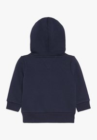 Sudadera con capucha azul marino con tela suave, mangas largas y capucha redondeada. Terminada con puños elásticos y un diseño sencillo en la parte trasera.