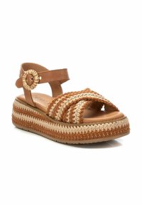 Sandal espadrille intrecciata marrone con cinturini incrociati, cinturino alla caviglia, accentuazione circolare e suola spessa stratificata in toni beige e marrone.