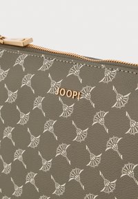 Saco de couro cinza com padrão floral branco em relevo, apresentando um logotipo dourado "JOOP!" e fecho de zíper dourado.