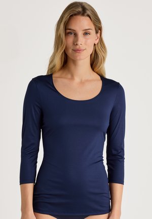 Navyblauwe langemouwen top met een ronde halslijn, gemaakt van een gladde stof, met een aansluitend ontwerp en mouwlengte tot halverwege de arm.