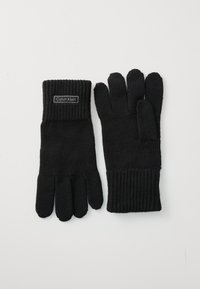 Sorte strikkede hansker med ribbestrikkede mansjetter, et merke med "Calvin Klein", og en standard fem-finger design. Stoffs tekstur virker myk.