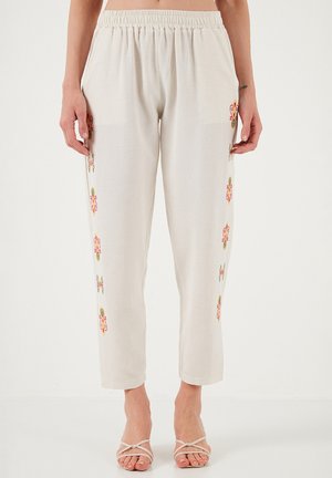 Pantaloni beige chiaro con vita elastica, dotati di colorati motivi floreali ricamati sui lati. Tessuto liscio e leggero.