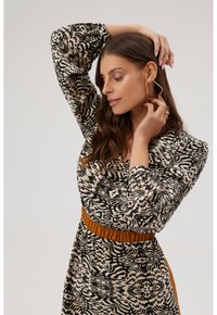 Sukienka drukowana z czarno-beżowym abstrakcyjnym wzorem, długimi rękawami bufkami i marszczonym pasem w kolorze bursztynowym. Gładka faktura tkaniny.