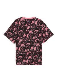 Sort t-shirt med all-over pink kranium mønster og et lille Puma-logo under den pink rundhalset halsudskæring på ryggen.