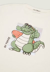 Krem majica od pamuka s crtić tematskim krokodilom u naočalama koji drži skateboard, s živopisnom grafikom i natpisom "HI THERE."