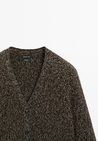 Bruin en wit gemêleerd gebreid cardigan met V-hals en twee zwarte knopen, gelabeld als 100% kasjmier van Massimo Dutti.