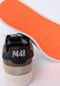 Sneaker con tomaia in suede grigia e beige, linguetta in pelle nera con "P448" ricamato in bianco e una suola a zigzag arancione brillante.