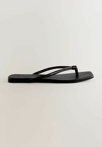 Juoda plokščia šlepetė su minimalistiniu dizainu, plonomis juostelėmis ir lygiu tekstūruotu padu, puikiai tinkanti kasdieniam dėvėjimui.