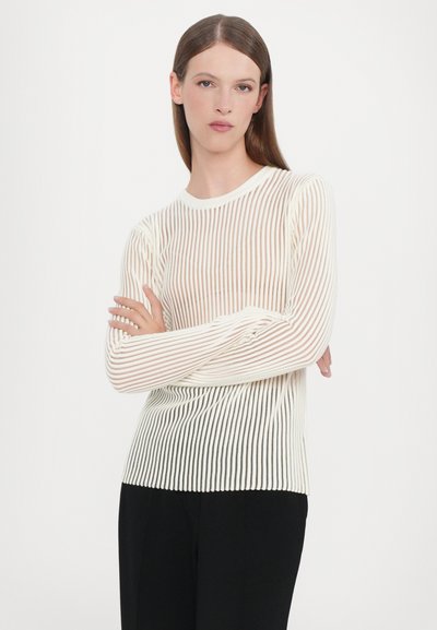 Lightweight, long-sleeve top featuring a ribbed texture and horizontal stripes in cream and white, paired with black trousers.