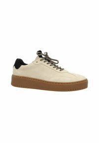 Baskets en daim beige avec des accents en fourrure noire, semelle en caoutchouc brun épais et lacets à motifs. Texture lisse avec un design low-top.