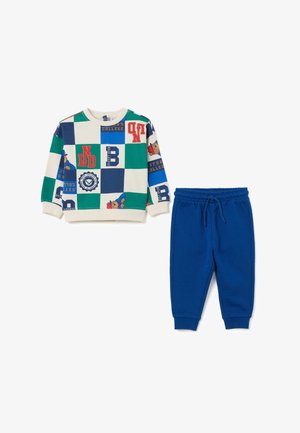 Sweatshirt met een multicolore dambordpatroon met letters en een berenafbeelding, gecombineerd met blauwe sweatpants met een elastische taille.