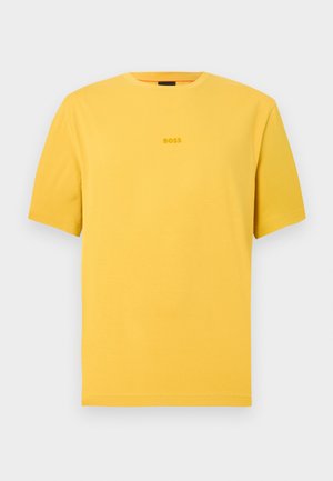 Lühikeste varrukatega, ümmarguse kaelusega T-särk erksas kollases puuvillas; keskosas on õrnalt reljeefne "BOSS" logo. Sile tekstuur, tavapärane lõige.