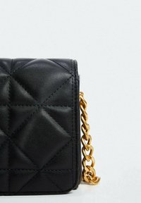 Czarna pikowana skórzana torba o prostokątnym kształcie, z złotym łańcuszkiem i teksturowanym diamentowym wzorem na powierzchni.