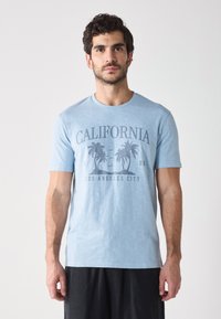 Svijetloplava pamučna majica s prednjim grafičkim prikazom palmi, natpisom "CALIFORNIA LOS ANGELES CITY" i klasičnim dizajnom okruglog izreza.