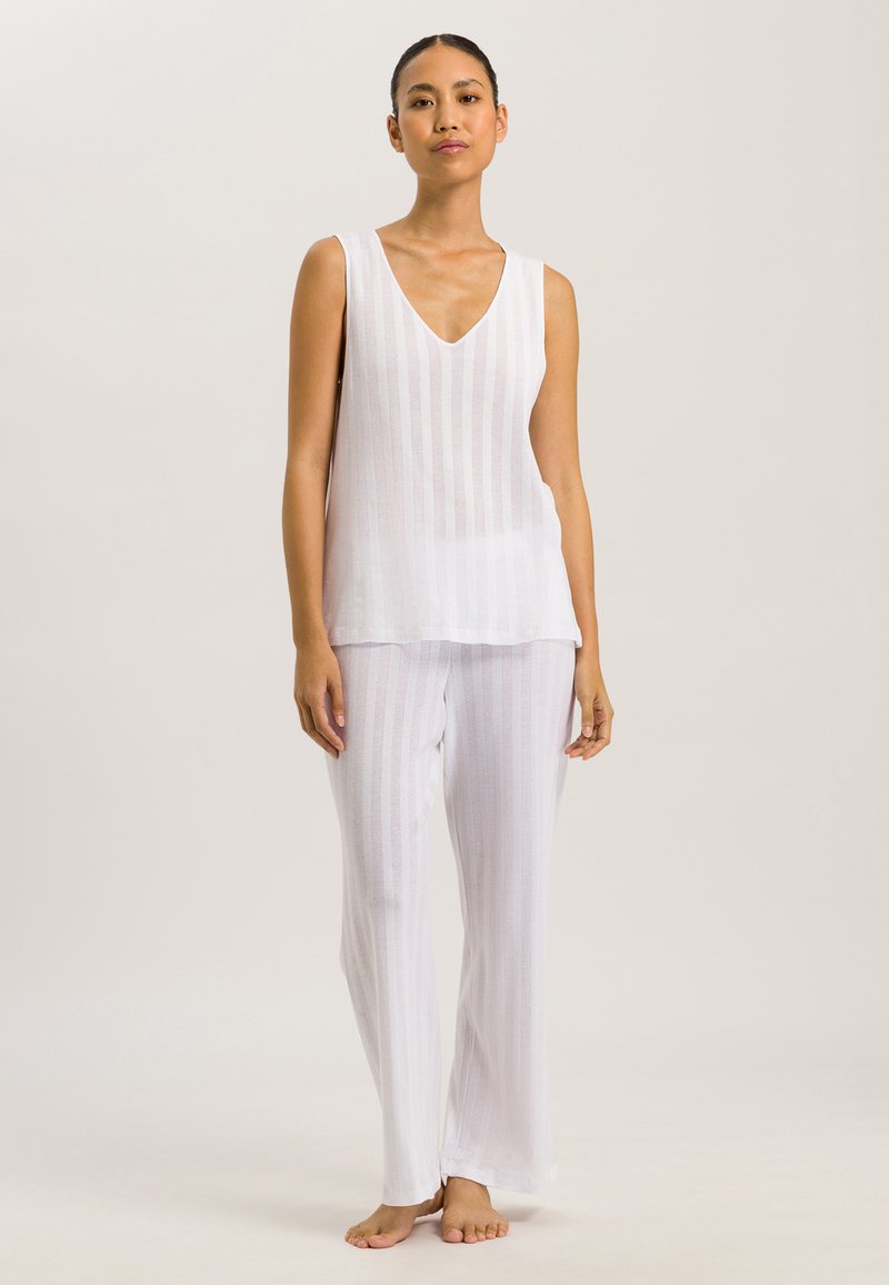 Completo leggero bianco in due pezzi, composto da un top senza maniche con scollatura a V profonda e righe verticali, abbinato a pantaloni con motivo a righe coordinato.