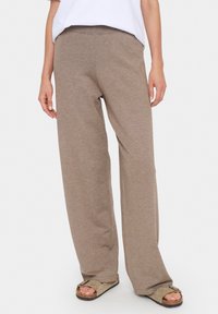 Ljusbruna, vida sweatpants i mjukt bomullsblandat material. Har resårmidja och en avslappnad passform.
