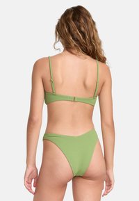 Completo bikini verde con tessuto testurizzato, spalline regolabili e un slip high-cut con design a forma di V sul retro.