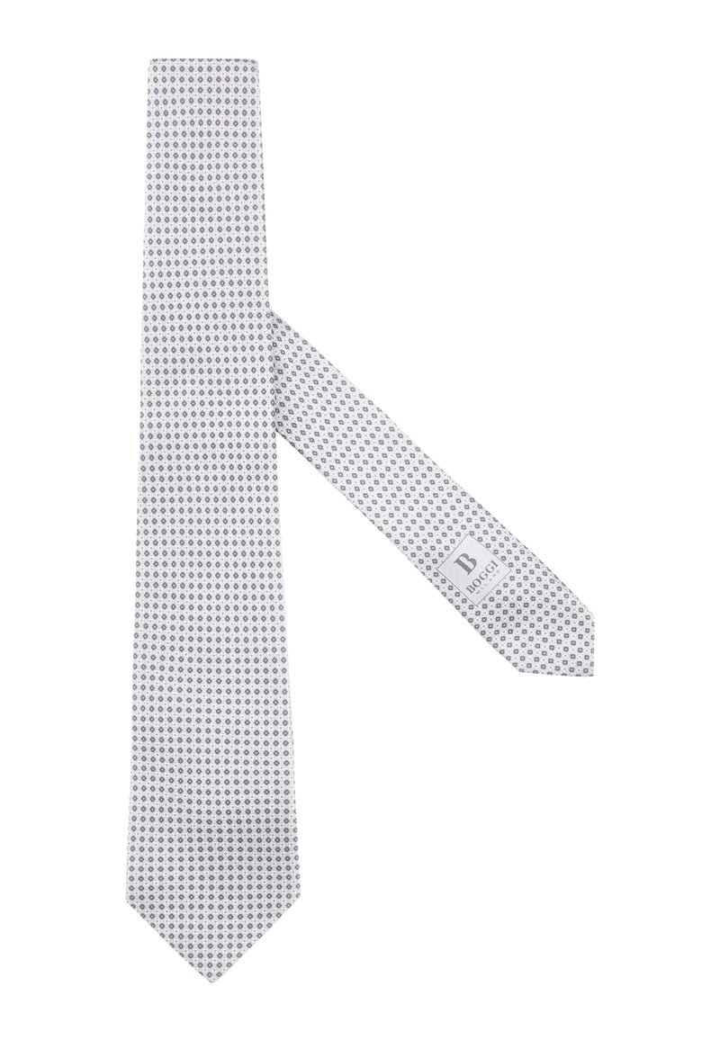 Cravate blanche avec un motif circulaire sombre bleu navy répétitif, en tissu lisse. Présente une étiquette de marque grise avec des lettres foncées.