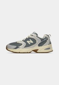 Gray mesh running shoe with light gray and cream accents, textured upper, reinforced toe, and rubber sole with tread pattern.