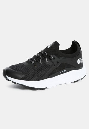 Czarno-biały sportowy sneaker z siatkową cholewką, wyściełanym kołnierzem, wzorzystymi sznurówkami i grubą białą podeszwą, oznaczony logo The North Face.