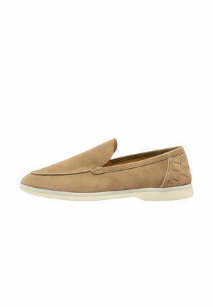 Mocassin beige en daim à enfiler avec semelle blanche et détail tissé sur le talon, conçu pour un port décontracté ou semi-formel.