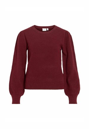 Vinrød strikkegenser med strukturert mønster, rund halslinning og puffede lange ermer. Tettsittende ved midjen med ribbestrikkede mansjetter.